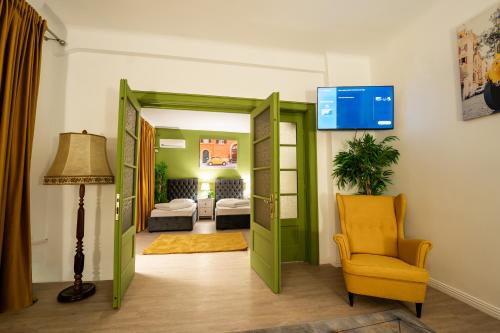 a living room with a green door and a yellow chair at Pit Stop Centrum in Ploieşti