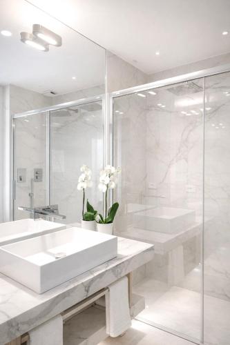 a white bathroom with a sink and a shower at Fiorentini Residence NAPOLI in Naples