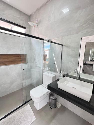 a bathroom with a toilet and a sink and a shower at Espaço completo MOTO GP in Aparecida de Goiânia