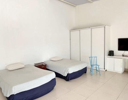 a bedroom with two beds and a blue chair at Espaço completo MOTO GP in Aparecida de Goiânia