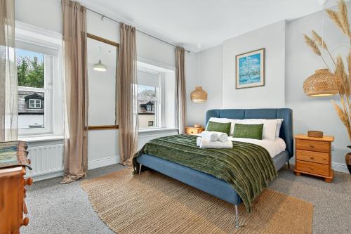 a bedroom with a blue bed and a window at Wolfe Tone Apartment 2 in Sligo