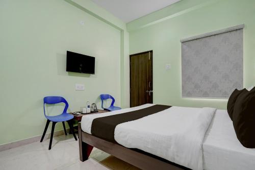 a bedroom with a bed and two blue chairs at Hotel O Dhauli Inn in Pānchagān