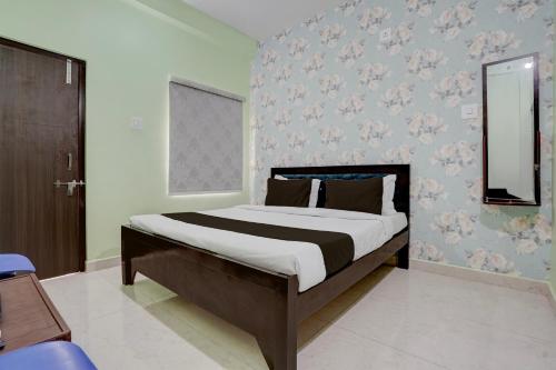 a bedroom with a large bed with a mirror at Hotel O Dhauli Inn in Pānchagān