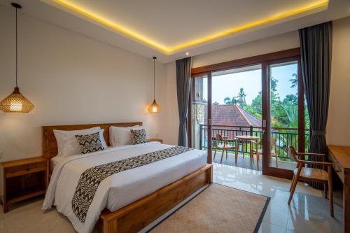 a bedroom with a bed and a balcony at Yoga Sri Ubud Hotel & Spa in Ubud