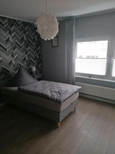 a bedroom with a bed and a window and a chandelier at Tinas Fewo 2 in Hohendodeleben