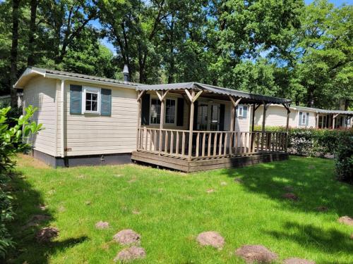 a small house with a porch on a yard at Chalet Spring voor 6 personen I Resort de Heimolen in Baarle-Nassau