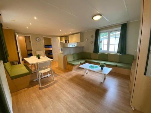 a living room with a couch and a table at Chalet Spring voor 6 personen I Resort de Heimolen in Baarle-Nassau
