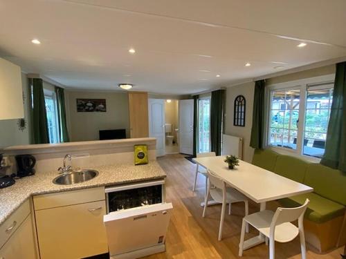 a kitchen and living room with a sink and a table at Chalet Spring voor 6 personen I Resort de Heimolen in Baarle-Nassau