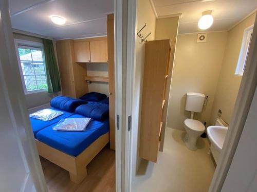 a small bedroom with a bed and a toilet at Chalet Spring voor 6 personen I Resort de Heimolen in Baarle-Nassau