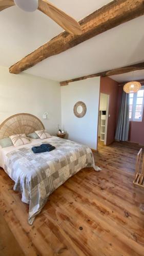 a bedroom with a large bed and a wooden floor at Chambre Terracotta privée et accès jacuzzi - sauna in Lézat-sur-Lèze