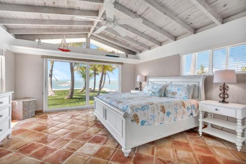 a bedroom with a bed and a large window at NEW!Paradise PointVIEWS!Open WaterDockPool! in Marathon