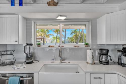a white kitchen with a sink and a window at NEW!Paradise PointVIEWS!Open WaterDockPool! in Marathon