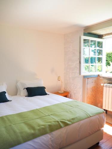 a bedroom with a large bed and a window at Quinta da Coutada - AgroTurismo in Arcos de Valdevez