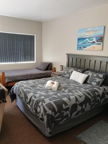 a bedroom with two beds and a window and a bed at 5 Bayview Gonubie Seaside in Gonubie
