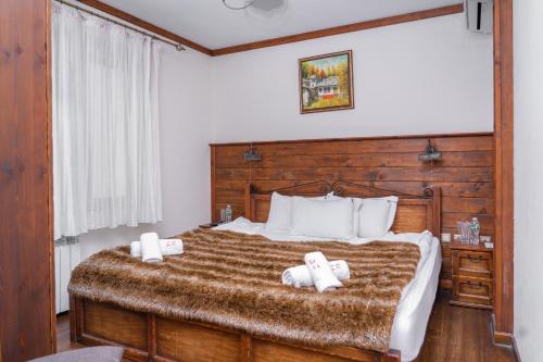 a bedroom with a large bed with two towels at Zlaten Rozhen Family Hotel- Monument of Cultural Significance in Rozhen
