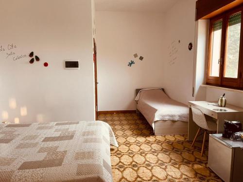 a bedroom with a bed and a desk and a window at Dolce VillaCastelli in Villa Castelli