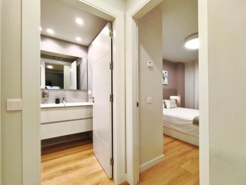 a bathroom with a sink and a bed in a room at Apt 1 hab Catedral III, Parking, Centro Valladolid in Valladolid