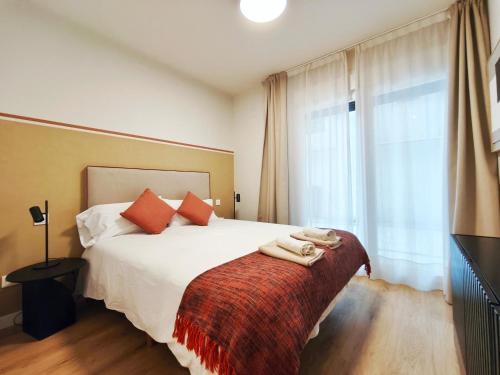 a bedroom with a white bed with a red blanket at Apt 2 hab Catedral II, Terraza, Parking, Centro in Valladolid