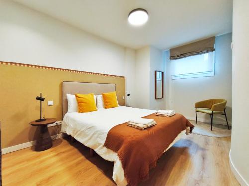 a bedroom with a large bed with yellow pillows at Apt 1 hab Catedral I, Centro Histórico in Valladolid