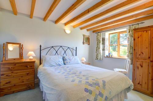 a bedroom with a bed and a dresser and a window at 2 Bed in Machynlleth oc-wad305 in Cemmaes