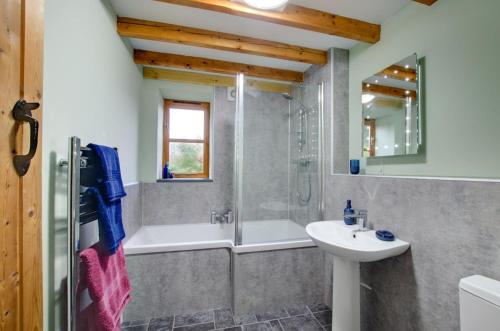 a bathroom with a tub and a sink and a shower at 2 Bed in Machynlleth oc-wad305 in Cemmaes