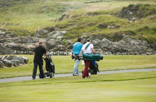 a group of people walking on a golf course at Margaret's Cottage B&B in Ardglass