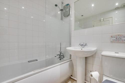a bathroom with a sink and a tub and a toilet at 2 Bed in Newton oc-bow124 in Porthcawl
