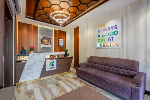 a lobby with a couch and a sign on the wall at Treebo Sri Anand Residency in Chennai