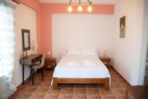 a bedroom with a bed and a table and a mirror at anatoli by the sea in Skala Mistegnon