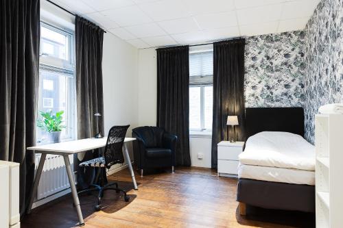 a bedroom with a desk and a bed and a table at Trossö Vandrarhem in Karlskrona