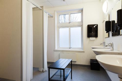 a bathroom with two sinks and a window at Trossö Vandrarhem in Karlskrona