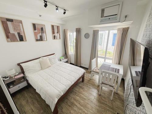 a bedroom with a bed and a chair and a window at Woodland Tagaytay in Tagaytay