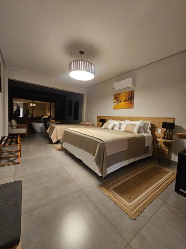 a large bedroom with a large bed and a bathroom at Vinícola e Hospedaria Bonventi Ltda in Espirito Santo Do Pinhal
