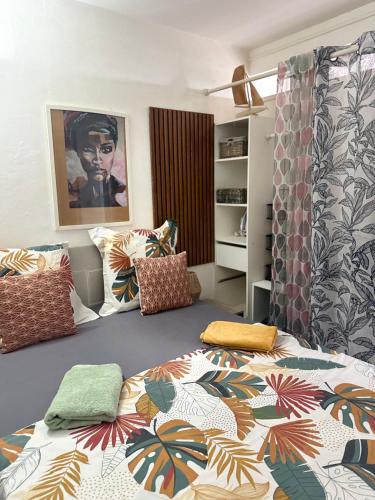 a bedroom with a bed with a colorful bedspread at Les Algues de la Chapelle in Anse-Bertrand