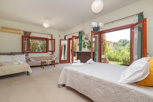 a bedroom with two beds and a large window at Casa Dentraki in Corfu