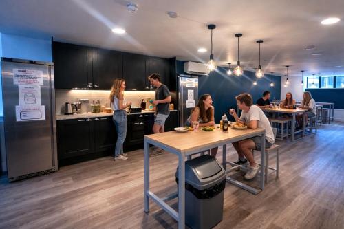 a group of people sitting at a table in a kitchen at Smart Camden Inn in London
