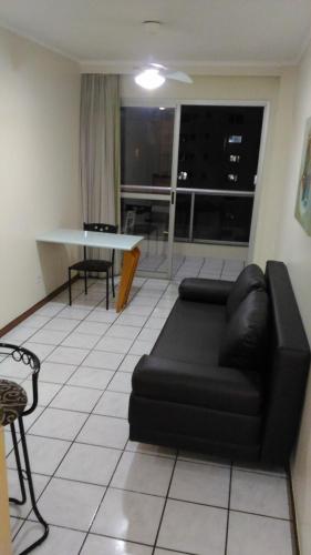 a living room with a black couch and a table at Apart Hotel Quartier Latin in Vitória