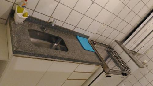a kitchen counter with a sink in a bathroom at Apart Hotel Quartier Latin in Vitória