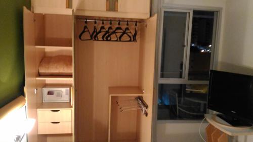 a small kitchen with a refrigerator and a window at Apart Hotel Quartier Latin in Vitória