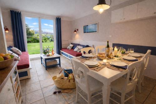 a kitchen and living room with a table and chairs at LocaLise - Maison E4 au Guilvinec - A 20m de la mer avec jardin et piscine - Tout à pied, plages, port, centre, commerces, marché - Wifi inclus - Linge de lit inclus - Animaux bienvenus in Le Guilvinec