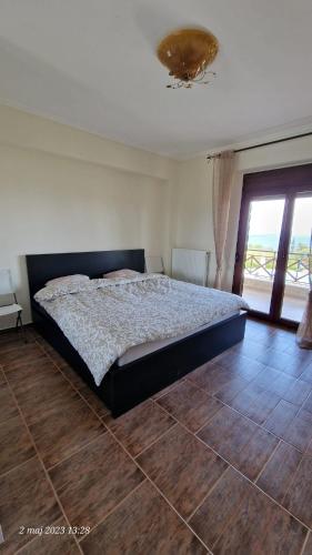 a bedroom with a large bed with a wooden floor at Villa Sandra in Kriopigi
