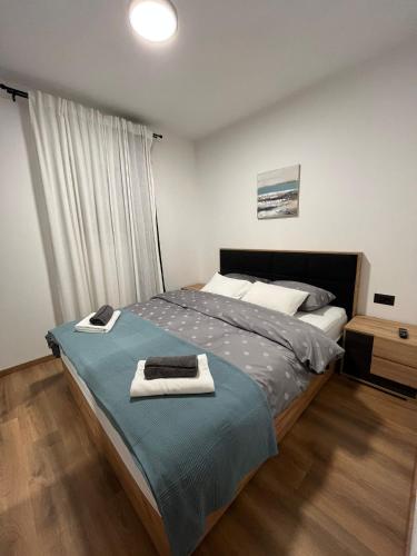 a bedroom with a bed with towels on it at Apartman A-lux in Blato