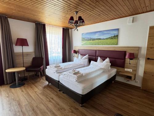 ein Hotelzimmer mit zwei Betten und einem Stuhl in der Unterkunft Hotel Weißbräu in Oberhaching