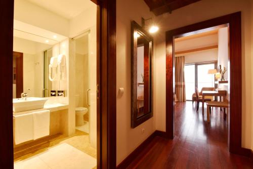 een badkamer met een wastafel, een toilet en een spiegel bij Pousada Convento de Tavira in Tavira