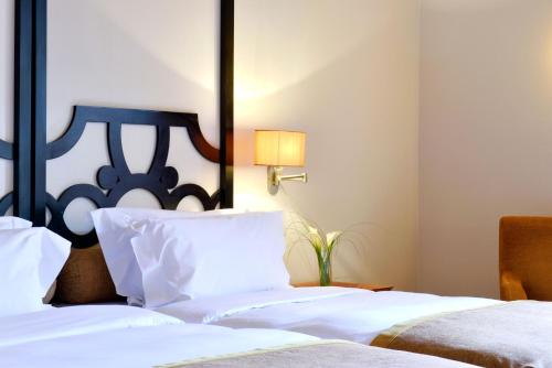 a bedroom with two white beds and a lamp at Pousada Convento de Tavira in Tavira