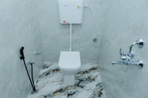 a bathroom with a white toilet in a marble wall at Hotel Ramkrishna Stay in Khajurāho