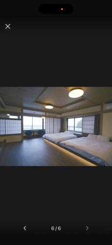 a large room with two beds and windows at Hokkawa Onsen Hotel in Higashiizu