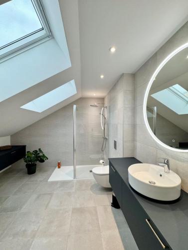 a bathroom with a sink and a mirror at La Maison Contemporaine, Luxe et Elégance aux portes de Rennes in Cesson-Sévigné