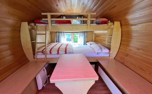 a small room with two bunk beds and a table at Schlaffässer am Haus der Schmetterlinge in Uslar