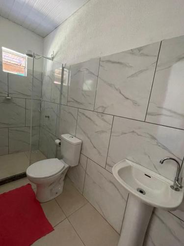 a white bathroom with a toilet and a sink at Lago Camping Sana in Macaé